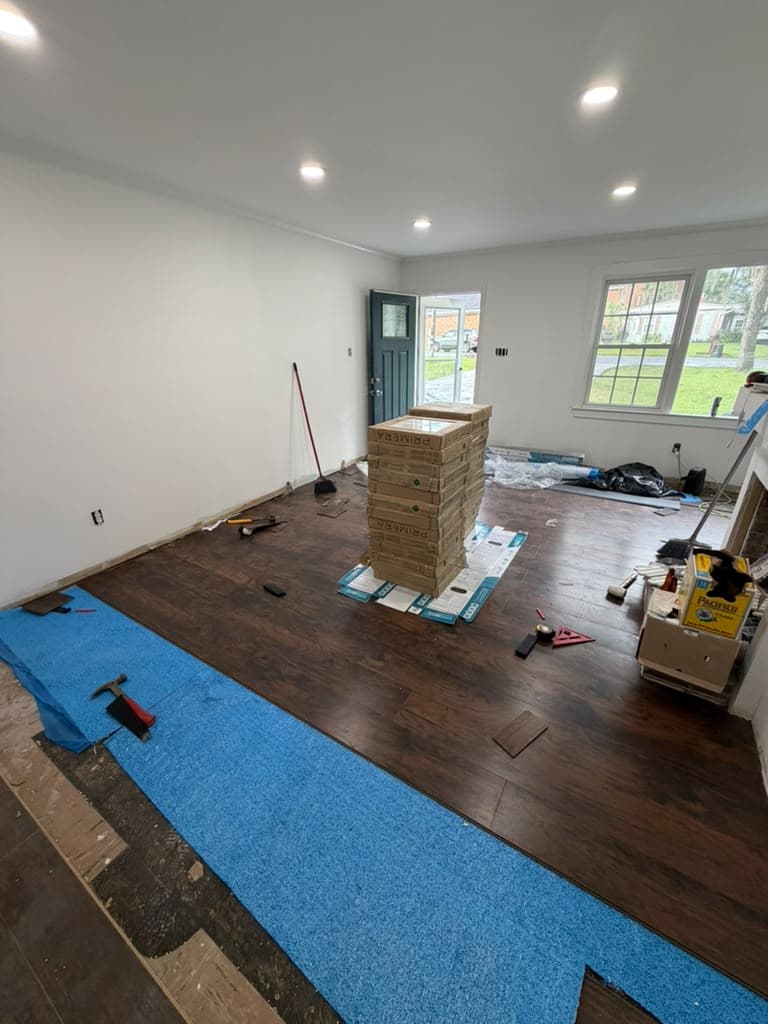 Dark LVP flooring installation in progress over underlayment